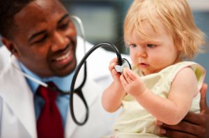 child playing with stethoscope with doctor
